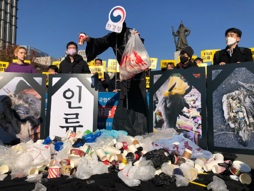 서울 광화문광장 이순신동상 앞에서 진행된 기자회견에서는 환경부 가면을 쓴 사신과 1회용품으로 죽어가는 동물, 사람의 영정사진이 시민들이 모아준 1회용품 쓰레기에 둘러싸여 있는 모습을 구현했다.녹색연합.jpg